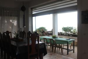 ein Esszimmer mit einem Tisch, Stühlen und einem Fenster in der Unterkunft RedDoorz Hostel Hardin De Corales La Union in San Fernando