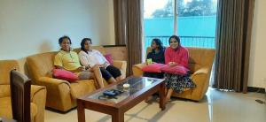 un grupo de personas sentadas en sofás en una sala de estar en Flamingo's Nuwara Eliya, en Nuwara Eliya