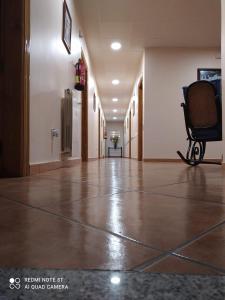 um corredor vazio com uma cadeira num edifício em Antiguo Casino de los Arribes em Fermoselle