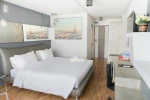 a bedroom with a white bed with a view of the eiffel tower at R1 Nimman Hotel Chiangmai in Chiang Mai