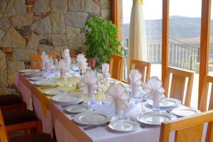 a long table with white plates and napkins on it at Mezena Resort & SPA in Lalībela