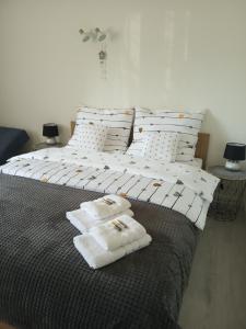 Una cama grande con almohadas blancas encima. en Apartamenty Na Skale en Szklarska Poręba