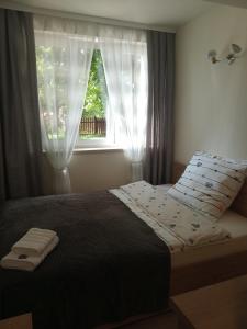 1 dormitorio con 1 cama y una ventana con cortinas en Apartamenty Na Skale en Szklarska Poręba