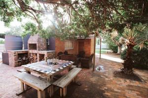 a patio with a picnic table and a fireplace at 90 On Wellington Cottage in Port Elizabeth