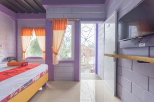 a childs bedroom with a bed and a window at RedDoorz @ Cipanas Garut in Garut