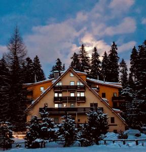 a large building in the snow with trees at Ski apartmány Spiežovec Donovaly in Donovaly