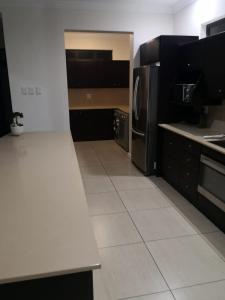 a kitchen with black and white counters and appliances at Blissful Beachfront Apartment - 11 Sovereign sands in KwaDukuza