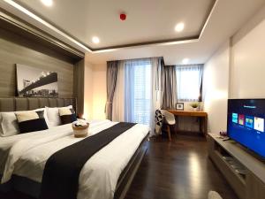 ein Schlafzimmer mit großem Bett und Flachbildfernseher in der Unterkunft Circle Rein Sukhumvit 12 #1BR#Pool&Gym#Near Terminal 21#Max2 in Bangkok