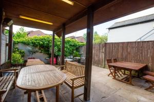 a patio with a wooden table and chairs and a table and benches at The Howard Arms in Brampton
