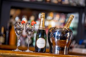 three bottles of wine and glasses on a bar at Howard Arms in Brampton +50 photos