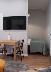 a living room with a table and a television at Studio 7 - Air-conditioned, P-spot & Self Check-in in Jyväskylä