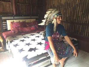a woman sitting on a bed in a room at Made Roejas Homestay in Uluwatu
