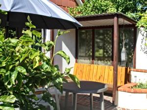 a gazebo with a table and a bench and an umbrella at Ferienhaus Heisch in Schafflund