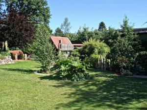 un patio con una casa y algunos arbustos y árboles en Ferienhaus Heisch, en Schafflund