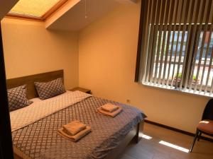 1 dormitorio con 1 cama con 2 toallas en Sofia Family House - Free Parking en Sofía