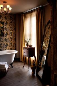 a bathroom with a bath tub and a window at The Crown And Thistle in Abingdon