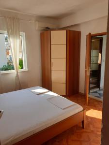 a bedroom with a bed and a closet and a window at Sunny place in Trpanj