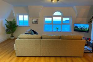 un soggiorno con divano e TV di Island Dhu View - Seaside Penthouse in Portrush a Portrush