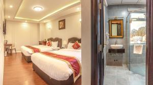 Postel nebo postele na pokoji v ubytování Queen T&T Dalat Hotel