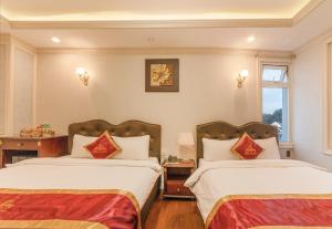 Postel nebo postele na pokoji v ubytování Queen T&T Dalat Hotel