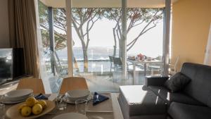 uma sala de estar com um sofá e uma mesa com fruta em Appartamenti BluMare em Diano Marina