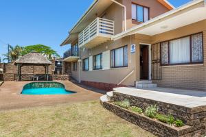 a house with a swimming pool in front of it at Whale-Inn in Durban