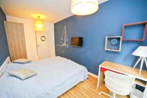 een slaapkamer met een wit bed en een blauwe muur bij Żeglarski Premium by Baltica Apartments in Sopot