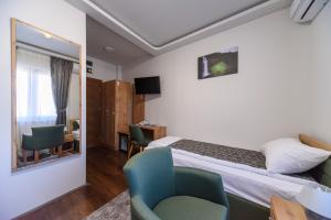 Un pat sau paturi într-o cameră la Garni Hotel Mala Moskva