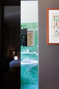 a bathroom with a sink and a room with a bed at Hotel Tremoggia in Chiesa in Valmalenco
