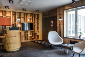 a living room with a television and wooden shelves at Vøringfoss Hotel in Eidfjord