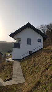 una casa blanca en la cima de una colina en Ferienwohnung Sonnenhang en Rüdenau