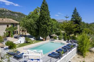 a swimming pool with lounge chairs and a villa at Villa Jaume Ramona in Pollença