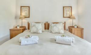 a large white bed with two pillows on it at Strandveld Vineyards Cottages in Elim