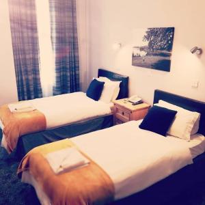 um quarto de hotel com duas camas num quarto em The Market Inn Hotel em Castle Douglas