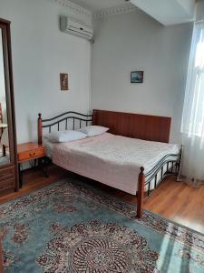 a bedroom with a bed and a rug at Hotel ВаYan in Shymkent
