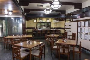 a restaurant with wooden tables and chairs and a kitchen at Nikkey Palace Hotel in Sao Paulo