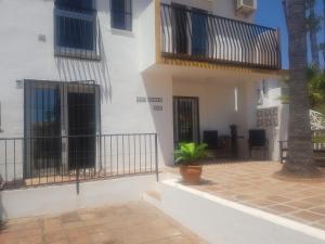 a white building with black doors and a patio at Casa Agnethe in Fuengirola