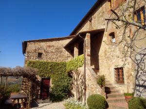 un vecchio edificio in pietra con sopra edera di Corzano e Paterno a San Casciano in Val di Pesa