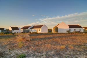 a row of houses in a field at De Hoop Collection - Village Cottages in De Hoop Nature Reserve