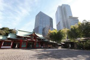 a temple in a city with tall buildings at The Capitol Hotel Tokyu in Tokyo