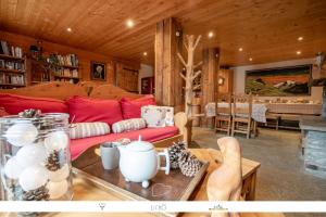 a living room with a red couch and a table at Chez Mamie Anna (B&B et Chalet) in Bessans