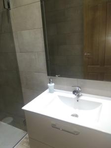 a bathroom with a white sink and a mirror at Apartamento La Agripina in Aldeadávila de la Ribera +8 photos
