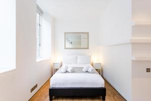 a bedroom with a bed with a mirror on the wall at Oxford Circus Designer Apartment in London