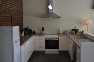 cocina con electrodomésticos blancos y pared de ladrillo en Hoeve Jadoul en Gingelom