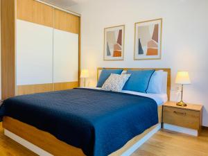 a bedroom with a blue bed with a blue bedspread at Gardenia Apartments in Sofia