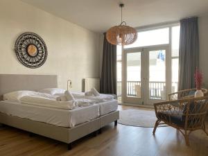 - une chambre avec un lit, une chaise et un lustre dans l'établissement Hotel Doppenberg, à Zandvoort