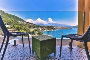 two chairs and a table on a balcony with a view of the water at Carine Hotel Kumbor Superior in Herceg-Novi