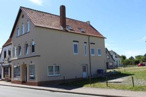 a large white building on the side of a street at Gaestehaus Dorum 01 in Dorum