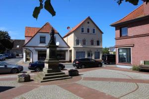 una estatua en medio de una calle con edificios en Gaestehaus Dorum 04, en Dorum