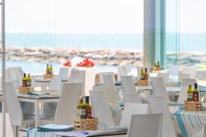 a room with white chairs and bottles of wine at Centro Vacanze Pra' delle Torri in Caorle
